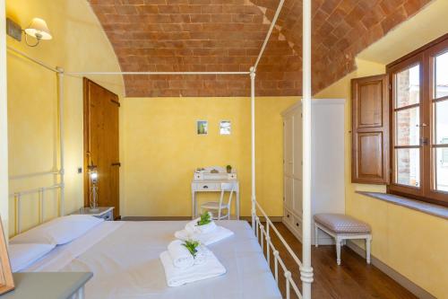 a room with a bed and a table and a chair at Appartamento Rosmarino in Lajatico