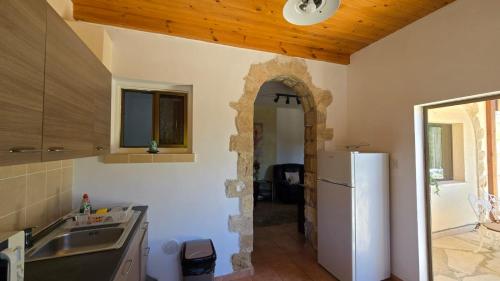 a kitchen with a sink and a refrigerator at Secluded Garden Studio in Tala
