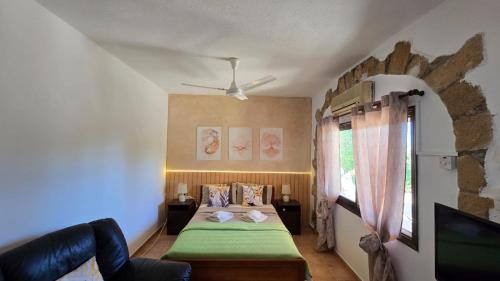 a bedroom with a bed with a green blanket at Secluded Garden Studio in Tala