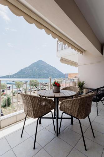a table and chairs on a balcony with a view of the ocean at NIMA Mytikas Apartments - Aitoloakarnania in Mitika