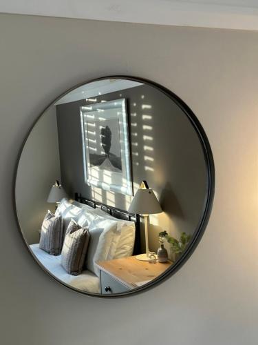 a mirror reflecting a bedroom with a bed with white pillows at The Old Bell B&B in Grimston