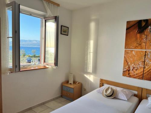 a bedroom with a bed and a large window at Apartments Vujic in Mirce