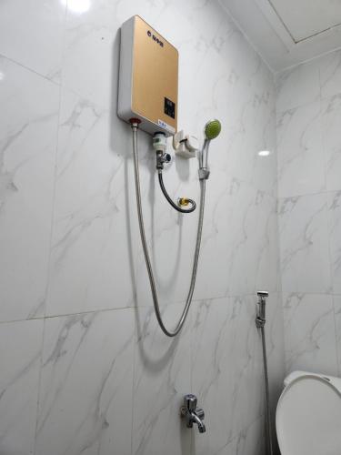 a shower in a bathroom with white marble walls at TANJIL RESTAURANT & Guesthouse in Phnom Penh