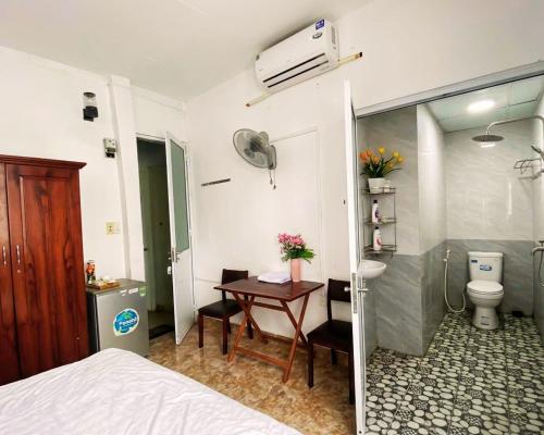 a bedroom with a bed and a table and a bathroom at Kavy Homestay in Thôn Trường Giang