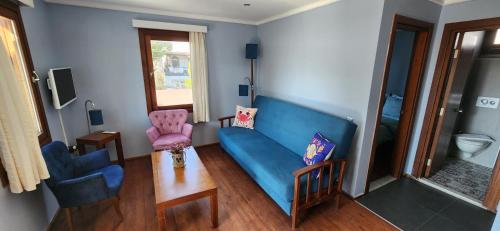 a living room with a blue couch and a chair at Bodrum Stone House Hotel in Bodrum City