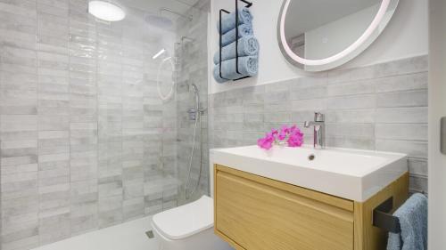 a bathroom with a sink and a toilet and a mirror at NEW AVATEA Parque Natural, piscinas y tennis in Corralejo