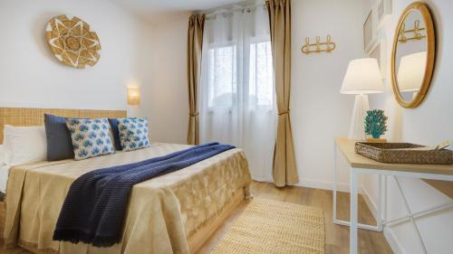 a bedroom with a bed with blue pillows and a mirror at NEW AVATEA Parque Natural, piscinas y tennis in Corralejo