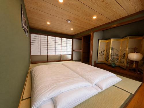 a large white bed in a room with a window at TAKIBEst Bnb&Bar in Takibe