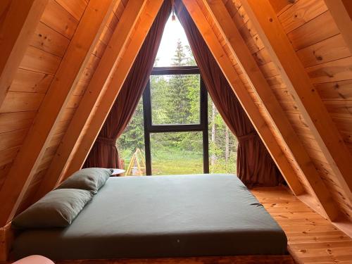 a bed in a room with a large window at Villa Aleksandra in Žabljak