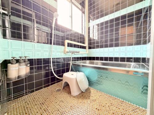 a bathroom with a tub and a toilet in it at ura 花れ -hanare- in Okayama