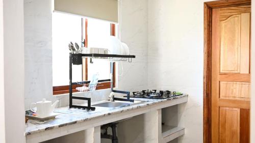 a kitchen counter with a sink and a mirror at La Maison Figaro Guest House - Spacious Island Stay in La Digue in La Réunion