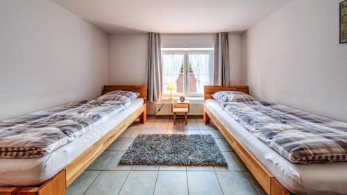 2 camas en una habitación con ventana en Haus Jansen, en Korschenbroich