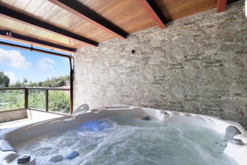 a bath tub in a room with a stone wall at El Alpendre in Moya