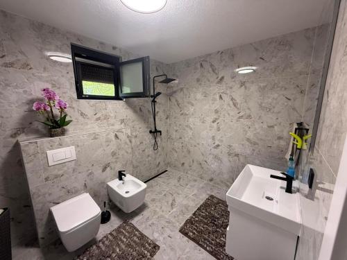 a bathroom with a white toilet and a sink at EMRAH RIVER UNA in Bihać