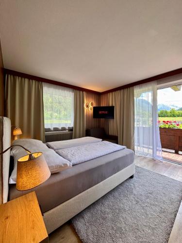 a bedroom with a large bed and a large window at Alpenhaus Monte Bike & Hike in Neustift im Stubaital