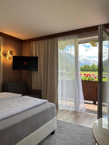 a bedroom with a bed and a window with a view at Alpenhaus Monte Bike & Hike in Neustift im Stubaital