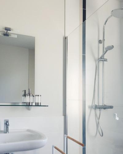 a white bathroom with a shower and a sink at Maison Gabriel - Jacuzzi in Pogny