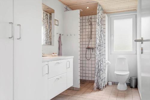 a white bathroom with a toilet and a shower at 1132-Ringkobing-Hvidbjergvej-32 in Søndervig