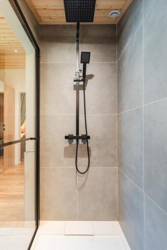a shower with a shower head in a bathroom at Le Chalet Madrier - Terrasse et Jacuzzi privé in Tours-en-Savoie