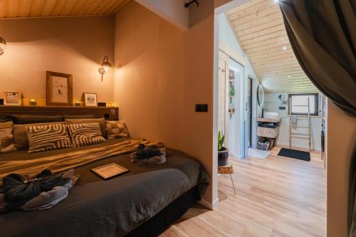 a bedroom with a bed and a hallway at Le Chalet Madrier - Terrasse et Jacuzzi privé in Tours-en-Savoie
