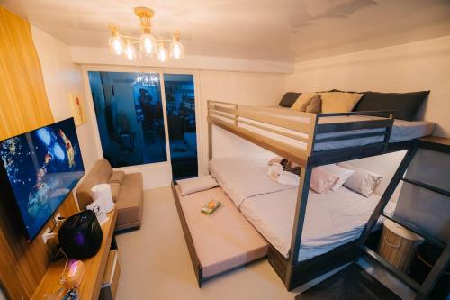 a small room with a bunk bed and a flat screen tv at G-Luxe Panabo Guesthouse - Unit B in Panabo