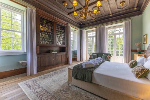 a bedroom with a large bed and a chandelier at Carcavelos Manor House by Portugal Active in Vila Verde