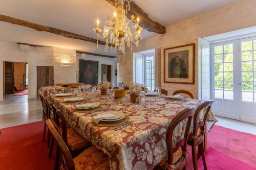 a dining room with a long table with chairs and a chandelier at Carcavelos Manor House by Portugal Active in Vila Verde