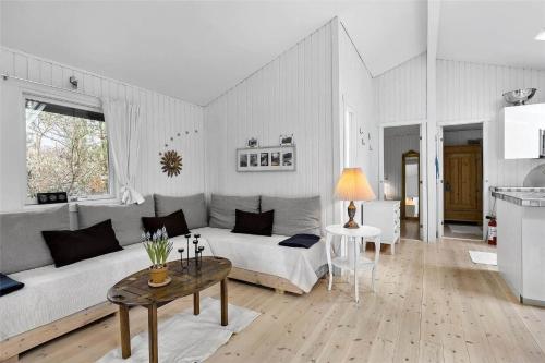 a white living room with a couch and a table at 1176-N-Hundested-Brune-Bakke-1 in Hundested