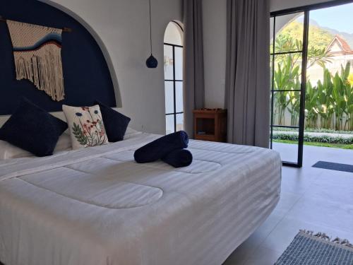 a bedroom with a large white bed with a large window at Bnaya Villas Riverside in Amed
