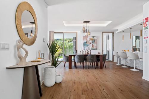 a living room with a dining room table and a mirror at Villa Platinum by Homie in Estreito da Calheta