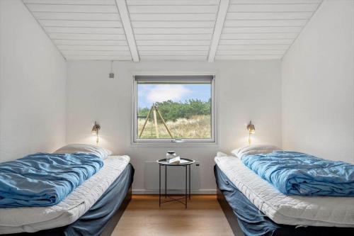 two beds in a room with a window at 239-Ringkobing-Vestklitvej-32 in Klegod