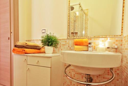 uma casa de banho com lavatório, espelho e toalhas em Il Perugino em Cagliari