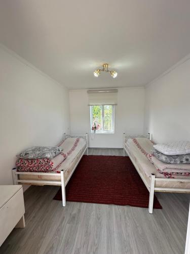 a bedroom with two beds and a window at Guesthouse'Hadicha' in Tong