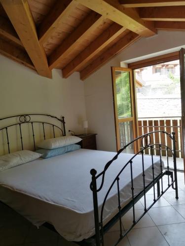 a bedroom with a bed and a large window at Residence La Pineta in Serina