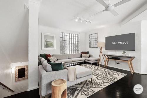a living room with a couch and a tv at Peggy - Little Cove in Noosa Heads