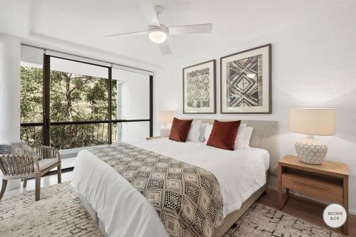 a bedroom with a large bed and a window at Peggy - Little Cove in Noosa Heads