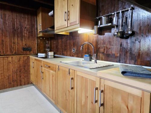 a kitchen with wooden cabinets and a sink at Casa das Candeias in Melgaço