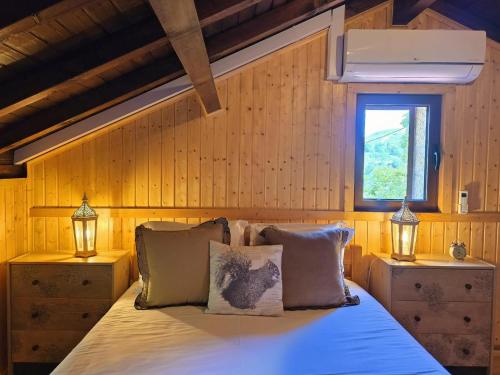 a bedroom with a bed with two lamps and a window at Casa das Candeias in Melgaço