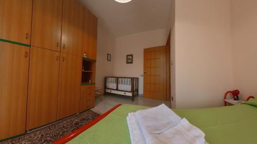 a bedroom with a green bed and wooden cabinets at La quiete dell'Ammiraglio 1 in Ioppolo