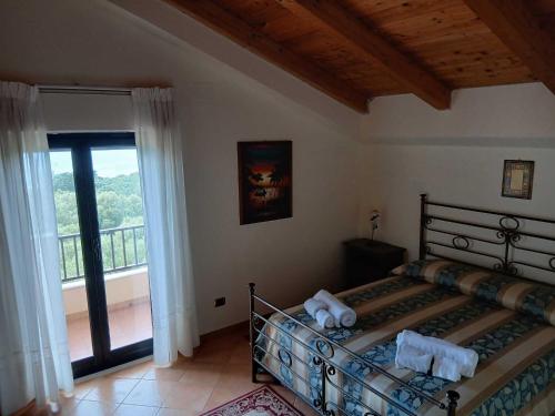 a bedroom with a bed with a view of a balcony at La quiete dell'Ammiraglio 2 in Ioppolo
