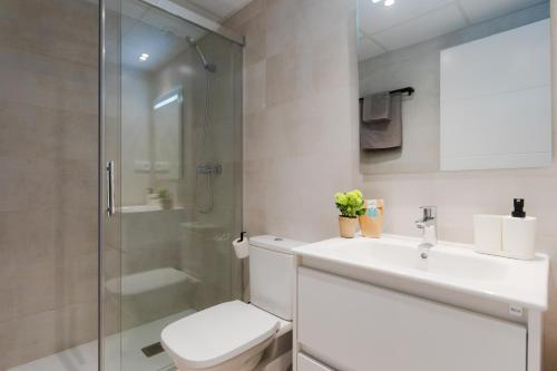 a bathroom with a toilet and a sink and a shower at Suiters Málaga in Málaga