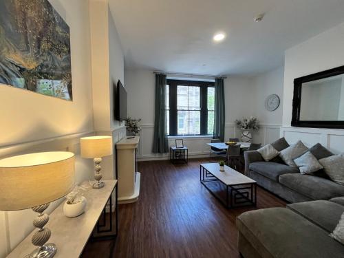 a living room with a couch and a table at Two bedroom flat in Cardiff Bay with roof terrace in Cardiff