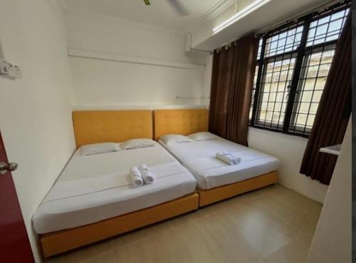 a bedroom with two beds with white towels on them at 7Rooms Hotel Budget in Bandar  Pusat Jengka