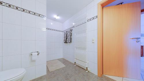 y baño blanco con aseo y ducha. en Haus Jansen, en Korschenbroich