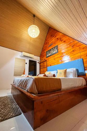 a bedroom with a large bed with a wooden wall at Rayonaz Resort in Dambulla