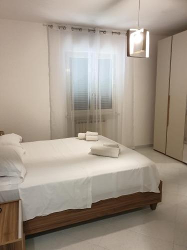 a white bedroom with a large bed with towels on it at Sperlonga ad un passo Casa Vacanza in Sperlonga