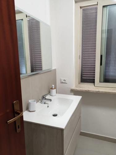 a white bathroom with a sink and a mirror at Sperlonga ad un passo Casa Vacanza in Sperlonga