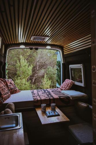 a room with a bed and a table and a window at Campervan Montenegro RV in Bar