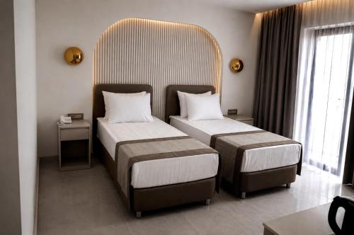 a hotel room with two beds and a large headboard at Alpek Hotel Antalya - Lara in Antalya