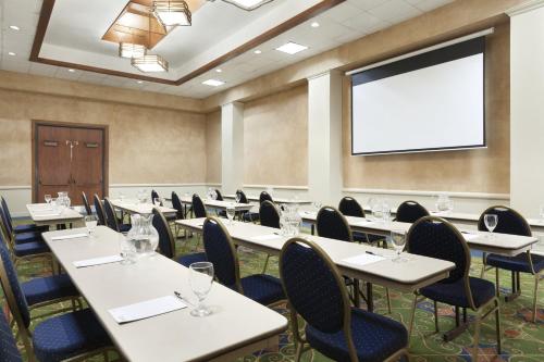 a conference room with tables and chairs and a screen at DoubleTree by Hilton Corpus Christi Beachfront in Corpus Christi